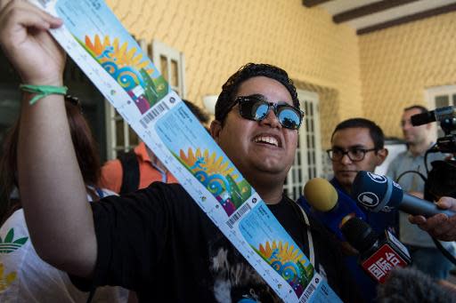 Un aficionado llamado Vanderson Balbino posa orgulloso con sus entradas para el Mundial, el 18 de abril de 2014, en Rio de Janeiro (AFP | YASUYOSHI CHIBA)