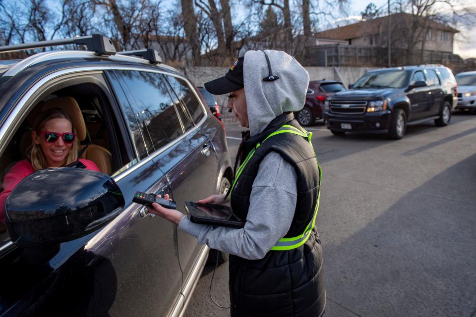 Raising Cane's Chicken Fingers crew member Layla Fridrich takes down customer Erica Burr's order at Raising Cane's newly designed drive-thru in Fort Collins on April 6, 2022.