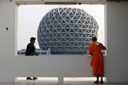 A soldier walks near a Buddhist monk from the Wat Phra Dhammakaya temple during an inspection of the temple, in Pathum Thani province, Thailand March 10, 2017. REUTERS/Chaiwat Subprasom