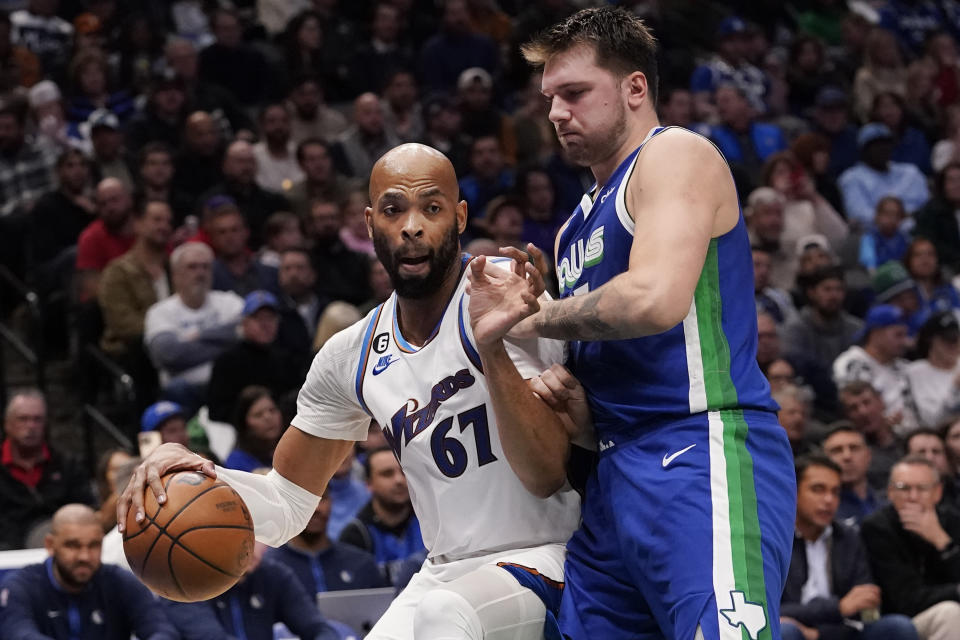 Washington Wizards forward Taj Gibson (67) dribbles against Dallas Mavericks guard Luka Doncic (77) during the first half of an NBA basketball game in Dallas, Tuesday, Jan. 24, 2023. (AP Photo/LM Otero)