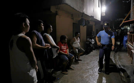 Resident watch policemen from Caloocan Police District as they patrol an alley at a residential district in Caloocan City Metro Manila Philippines, September 14, 2017. REUTERS/Erik De Castro