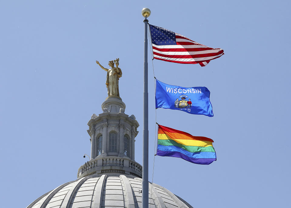 A rainbow flag observing Pride Month is displayed over the east wing of the Wisconsin State Capitol in Madison, Wis., Friday, June 7, 2019. The display, endorsed by Democratic Gov. Tony Evers, drew backlash from conservative Republican lawmakers who said it was divisive, while Democrats hailed it as a sign of inclusivity. (John Hart/Wisconsin State Journal via AP)