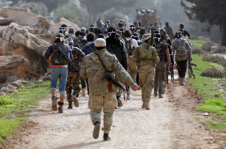 Turkish-backed Free Syrian Army fighters walk as they advance north of Afrin, March 6. REUTERS/Khalil Ashawi