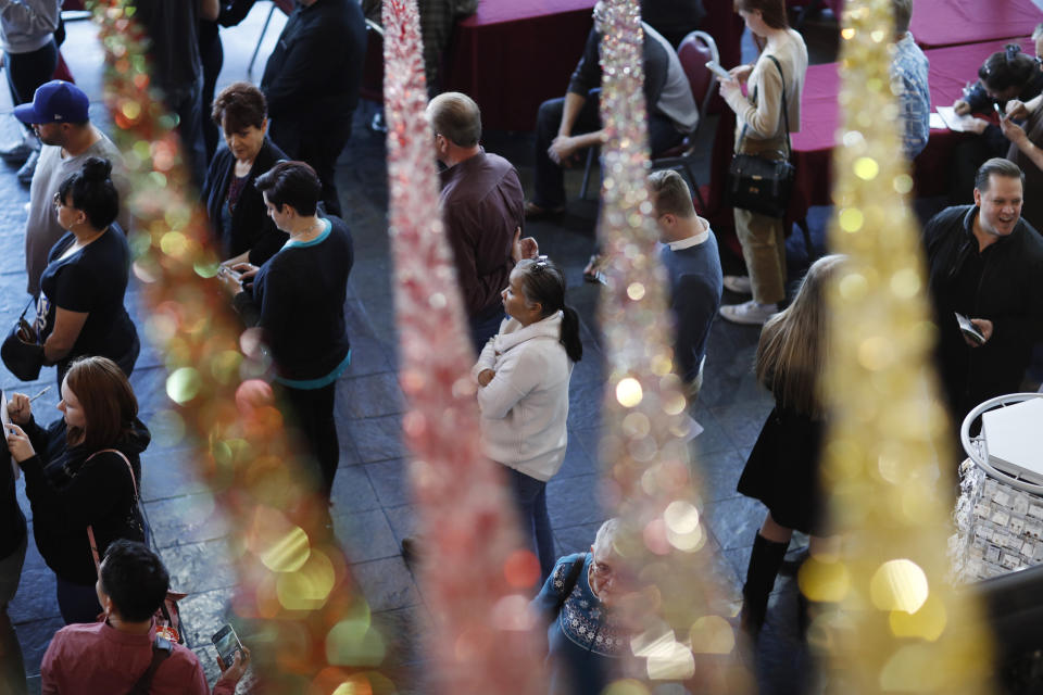 People wait in line at an early voting location in the Chinatown Plaza, Saturday, Feb. 15, 2020, in Las Vegas. (AP Photo/John Locher)