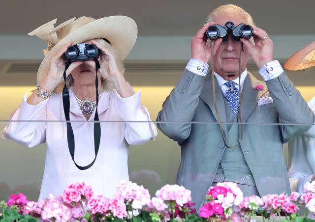 <p>Chris Jackson/Getty </p> Queen Camilla and King Charles watch a race with binoculars at Royal Ascot 2023