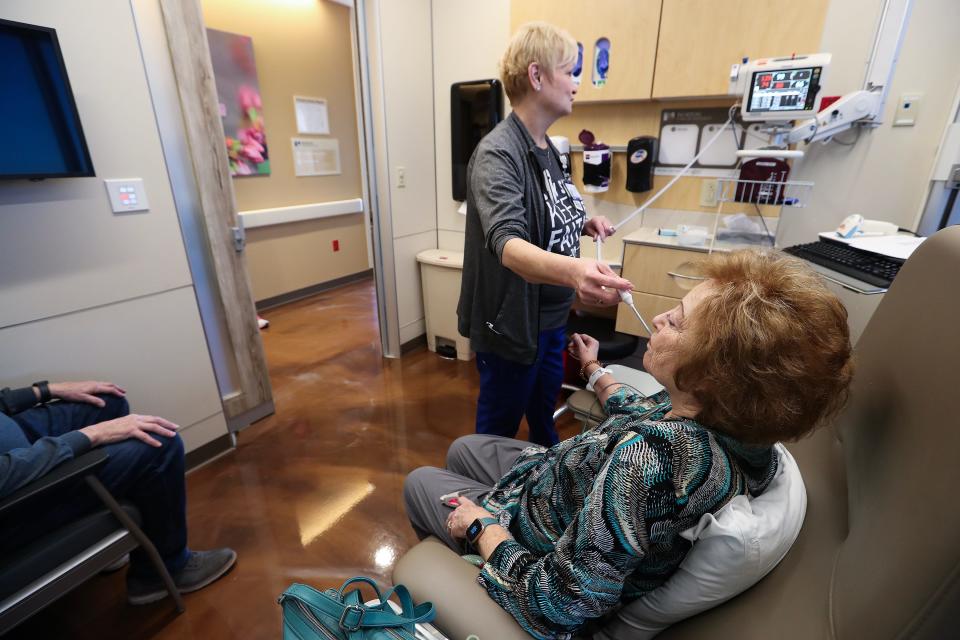 Registered nurse Jo Richardson, left, takes Bobbie West's temperature before she receives her 12th infusion treatment for Alzheimer's at the Norton Cancer Institute in Louisville, Ky. on Feb. 20, 2024.