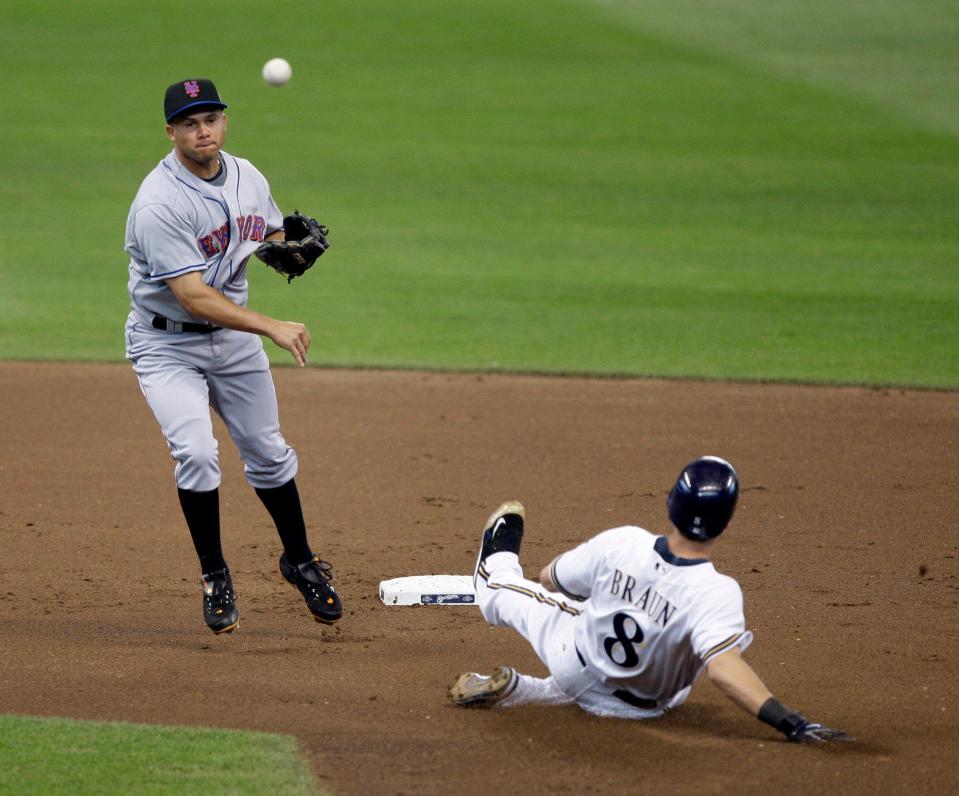 New York Mets' Argenis Reyes turns a double play with Milwaukee Brewers' Ryan Braun sliding during the first inning of a baseball game Monday, June 29, 2009, in Milwaukee. (AP Photo/Morry Gash) 