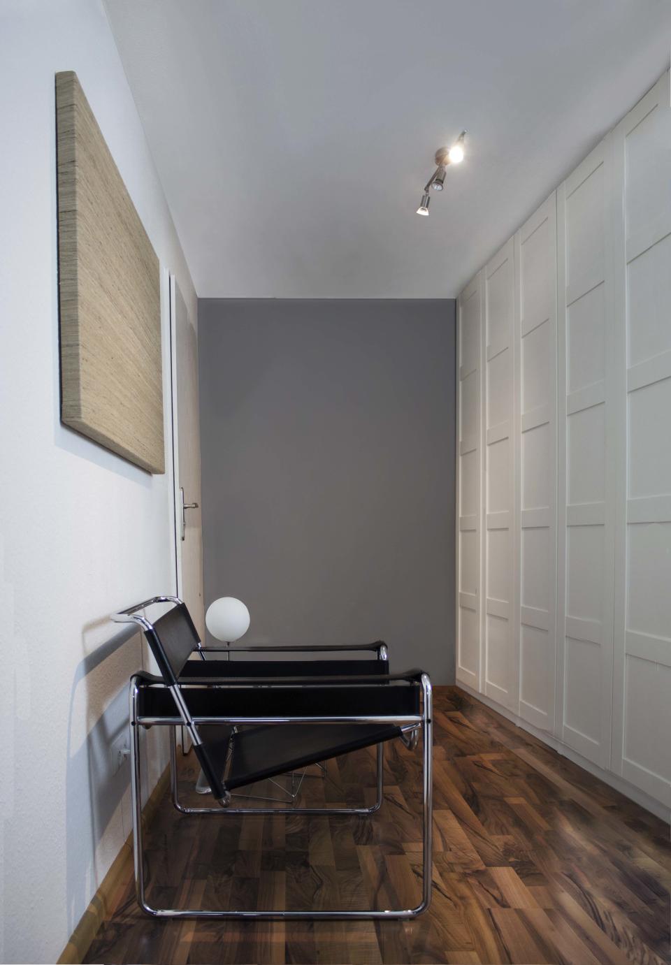 Talitha and Michael chose to install a large, floor-to-ceiling wardrobe—a PAX system from IKEA—to keep clutter out of sight in the entryway. Another Wassily Chair and a Vitra Occasional Table make for a quick place to put on shoes or drop keys, while the grey wall near the door elongates the space. One of ZWEI Design’s AC Globe Table Lamps hangs out next to the chair for soft lighting.