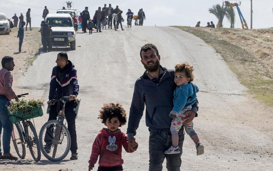 Displaced Palestinians walk after the Israeli army told residents of the Hamad area in Khan Yunis to leave their homes and head towards Rafah, near the border with Egypt