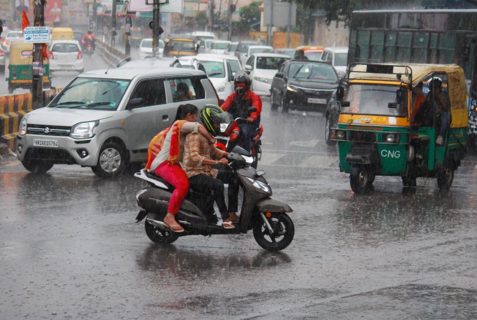 <div class="paragraphs"><p>Commuters wade through water amid heavy rain in Gurugram on Sunday, 17 October.</p></div>