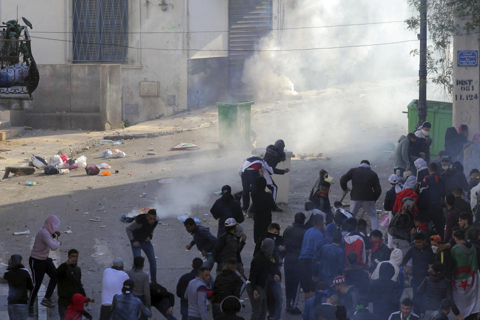 Protestors clash with police officers during a demonstration against the country's leadership, in Algiers, Algeria, Friday, April 12, 2019. Heavy police deployment and repeated volleys of water cannon didn't deter masses of Algerians from packing the streets of the capital Friday, insisting that their revolution isn't over just because the president stepped down. (AP Photo/ Fateh Guidoum)