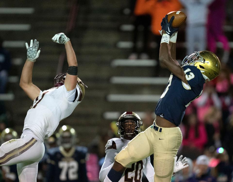 Cathedral wide receiver Jaron Tibbs (13) goes up for a catch over Brebeuf Jesuit’s Nolan Buckman (11) on Friday, Oct. 7, 2022, in Indianapolis. 