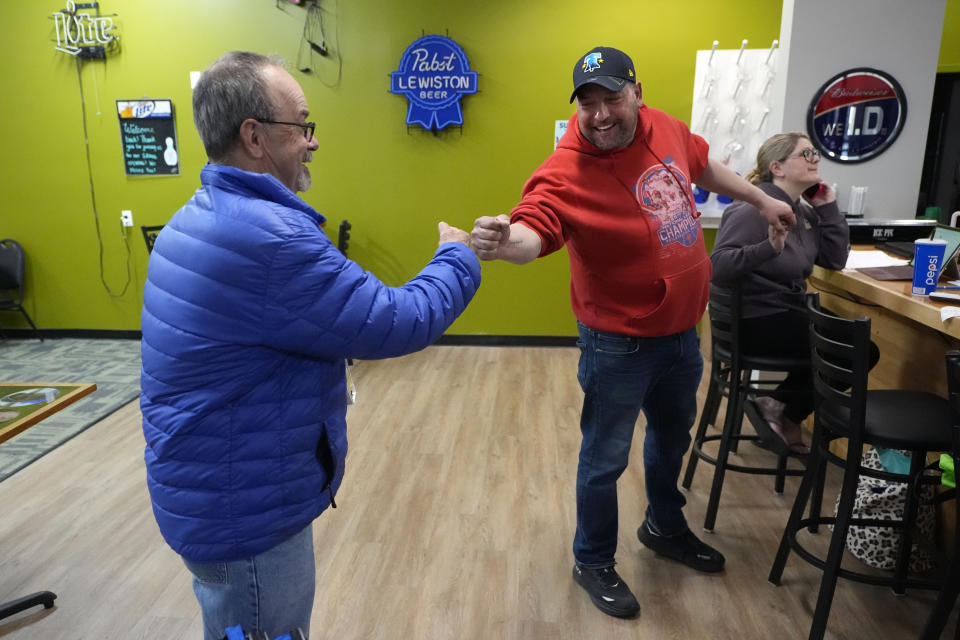 Justin Juray, right, owner of Just In Time Recreation, bumps fists with local bowler Moe St. Pierre, Wednesday, May 1, 2024, in Lewiston, Maine. The bowling alley, where eight people were killed in last October's mass shooting, was scheduled to reopen Friday, May 3. (AP Photo/Robert F. Bukaty)