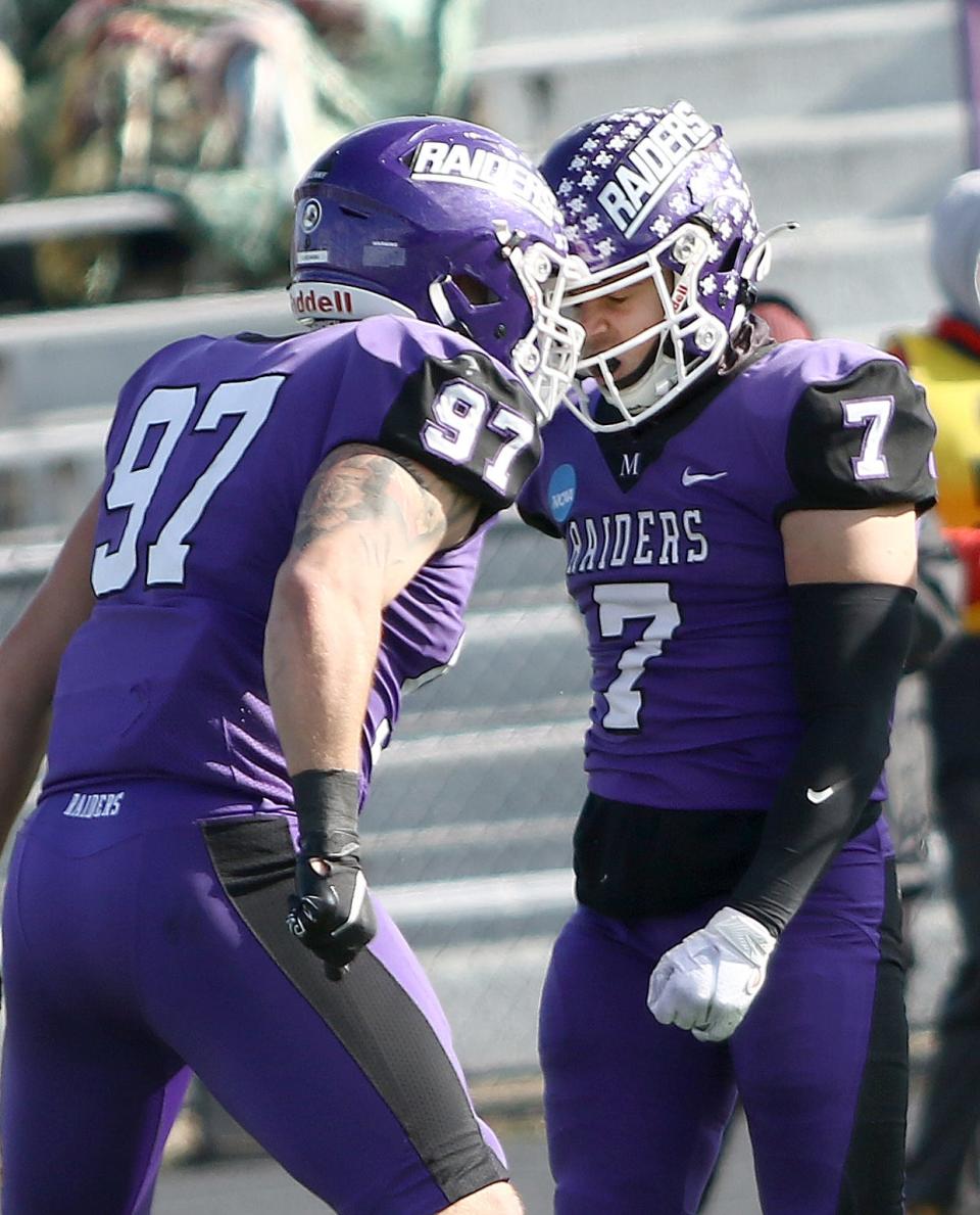 Mount Union's Luke Lukowski (97) headbutts teammate Jesse Vail (7) after Vail's open field tackle of a Salisbury runner during an NCAA playoff game at Kehres Stadium Saturday, November 19, 2022.