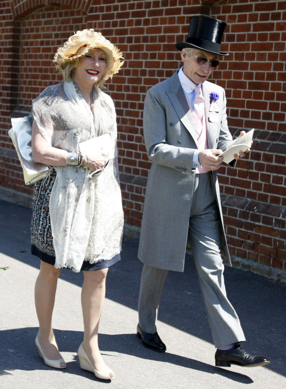FILE - Charlie Watts, the drummer of the Rolling Stones, with his wife Shirley, arrive on the third day of the Royal Ascot horse racing meeting at Ascot, England, Thursday, June, 17, 2010. Shirley Ann Watts, a former art student and prominent breeder of Arabian horses who met drummer Charlie Watts well before he joined the Rolling Stones and with him formed one of rock's most enduring marriages, has died at age 84. "Shirley died peacefully on Friday 16th December in Devon after a short illness surrounded by her family," her family announced Monday, Dec. 19, 2022. (AP Photo/Alastair Grant, File)