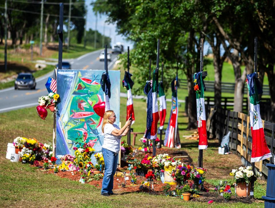Mary Strouse of Dunnellon takes pictures of the roadside memorial for the eight killed in a migrant worker bus accident Monday afternoon, May 20, 2024. The accident occurred on Tuesday morning, May 14, 2024. The roadside memorial is complete and some people stopped by to pay their respects Monday. Artist Roberto Marquez from Dallas, Texas created the roadside memorial. "I feel this will be like a temple. You'll see the names on the crosses and a bench to sit and meditate or pray," Artist Roberto Marquez said. Passersby either stopped to pay their respects, drop off flowers or light candles for those killed in the bus accident near Dunnellon on West Hwy. 40. Marquez did erect eight crosses for those that died. "When you see it next time, you won't recognize it," Marquez said on Wednesday May 15, 2024. [Doug Engle/Ocala Star Banner]2024