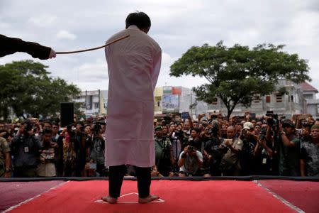FILE PHOTO: An Indonesian man is publicly caned for having gay sex, in Banda Aceh, Aceh province, Indonesia May 23, 2017. REUTERS/Beawiharta/File Photo