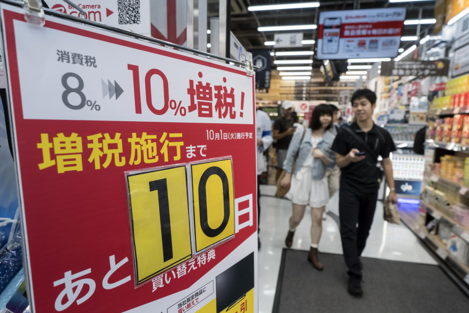 TOKYO, JAPAN - SEPTEMBER 21: A couple walks past a sign notifying consumption tax increase outside a store on September 21, 2019 in Tokyo, Japan. Japanese consumers are preparing ahead of the planned consumption tax hike from 8 percent to 10 percent on October 1. (Photo by Tomohiro Ohsumi/Getty Images)