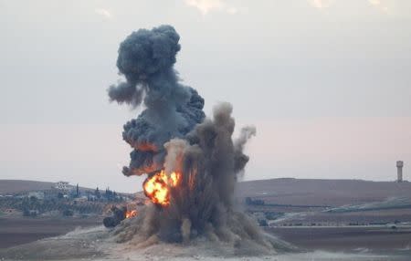 Smoke and flames rise over a hill near the Syrian town of Kobani after an airstrike, as seen from the Mursitpinar crossing on the Turkish-Syrian border in the southeastern town of Suruc in Sanliurfa province, October 23, 2014. REUTERS/Kai Pfaffenbach