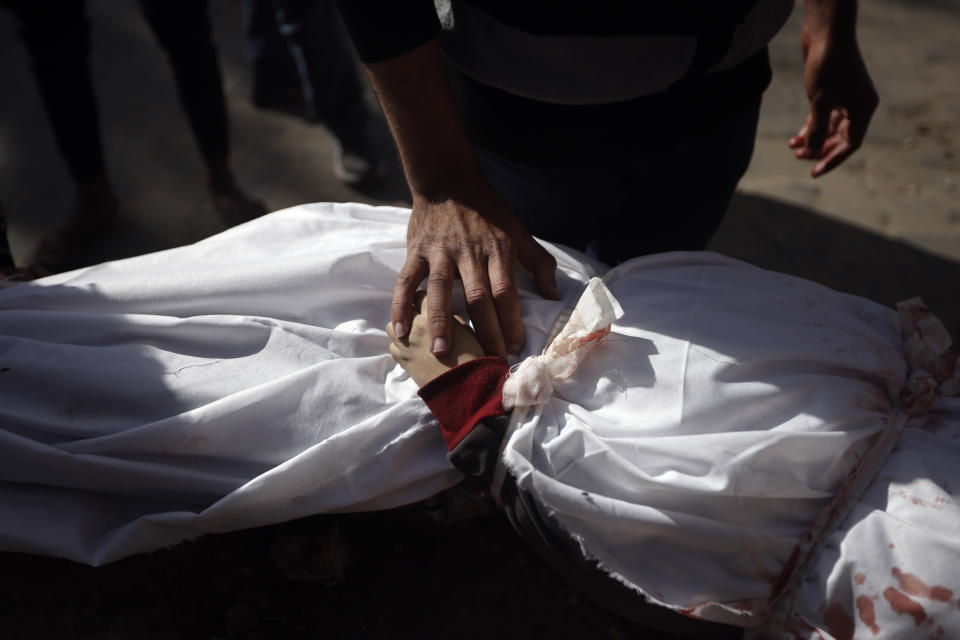 A Palestinian man mourns over the body of a child killed in the Israeli bombardment of the Gaza Strip, at Nasser hospital in Khan Younis, Monday, Jan. 22, 2024. (AP Photo/Mohammed Dahman)