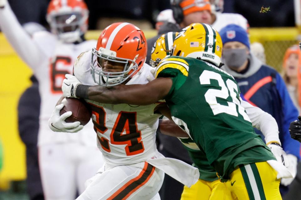 Green Bay Packers' Darnell Savage tries to stop Cleveland Browns' Nick Chubb during the first half of an NFL football game Saturday, Dec. 25, 2021, in Green Bay, Wis. (AP Photo/Matt Ludtke)