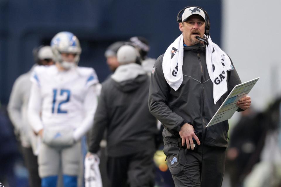 Lions coach Dan Campbell speaks on his helmet during the first half, Sunday, Jan. 2, 2022, in Seattle.
