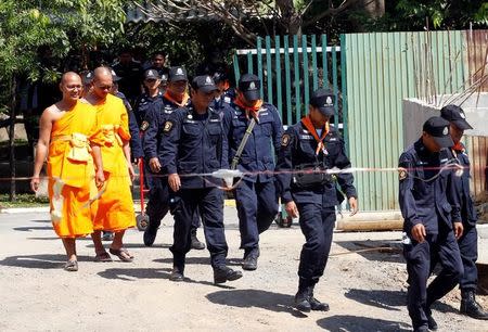 Policemen and Buddhist monks search for a fugitive Buddhist monk inside Dhammakaya temple in Pathum Thani province, Thailand February 17, 2017. REUTERS/Chaiwat Subprasom