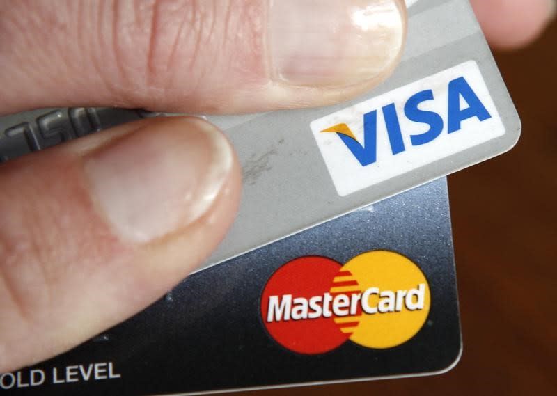 A credit card user displays her cards in Washington February 22, 2010. REUTERS/Kevin Lamarque/Files