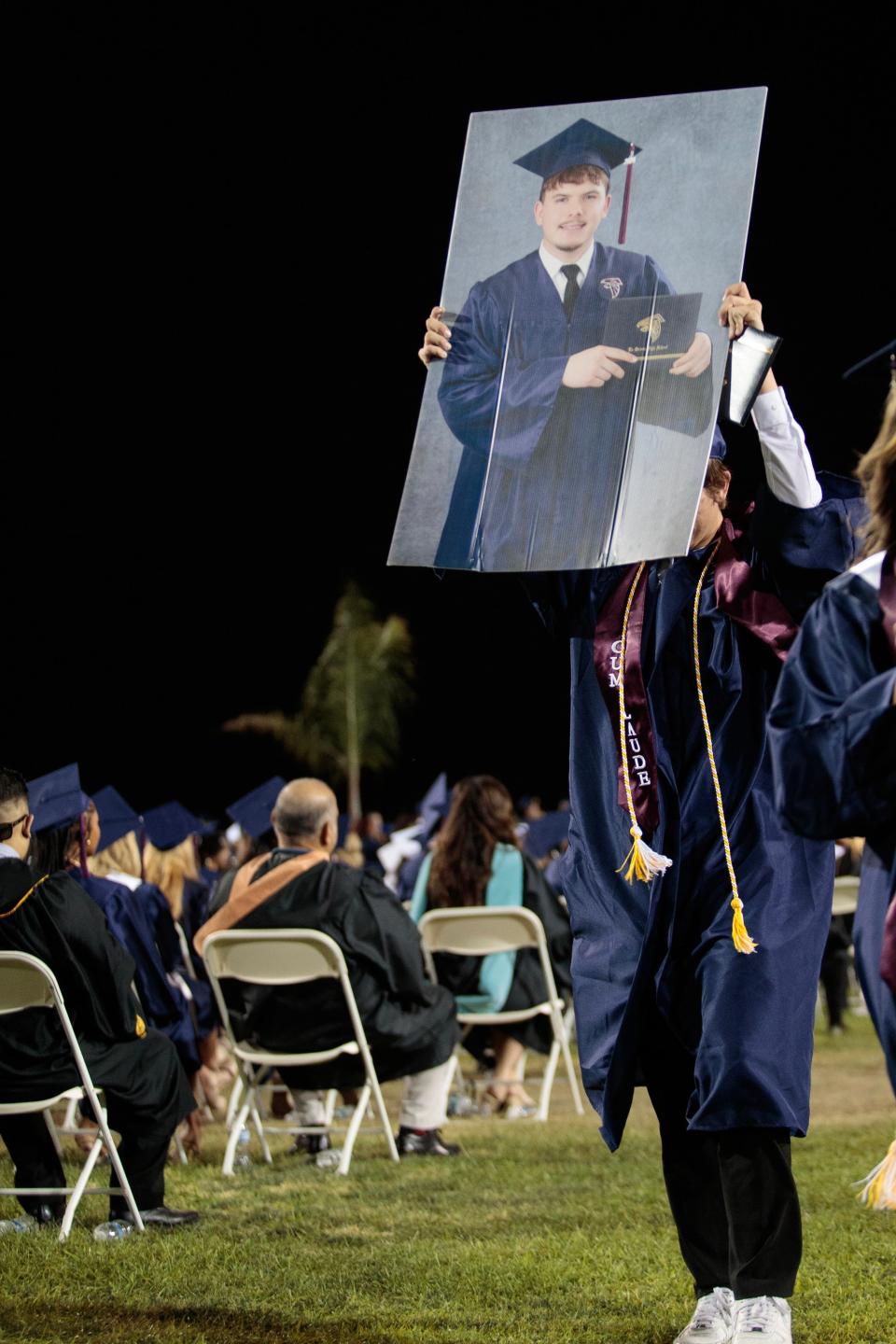 Aidan Fetzer holds a photograph of his best friend, Jaden Ramos, while receiving his diploma during the La Quinta High School Class of 2024 commencement Thursday.