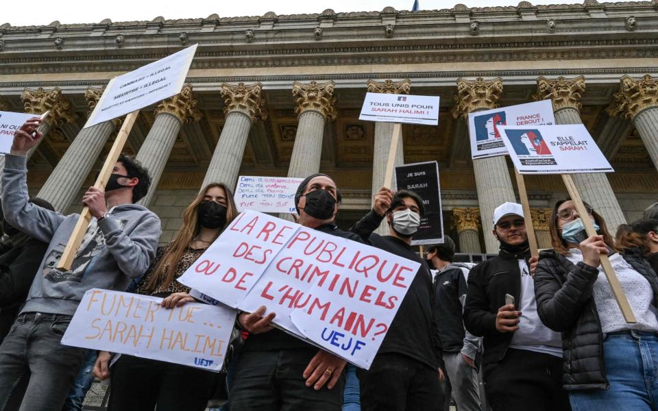Protesters hold placards - PHILIPPE DESMAZES / AFP
