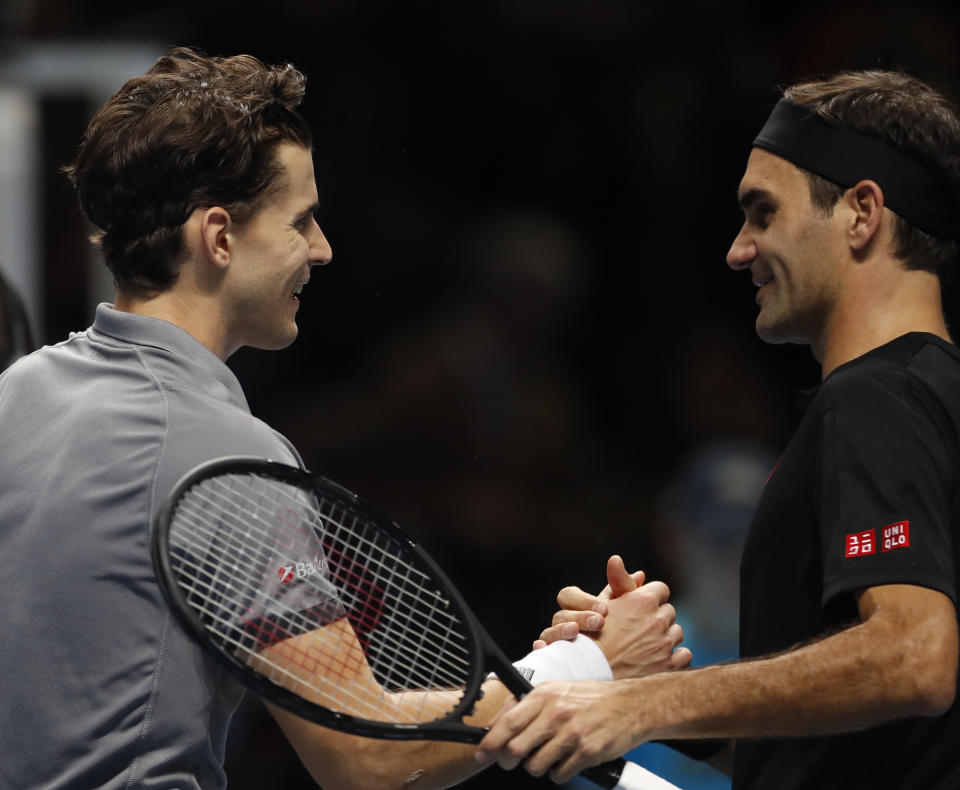 Switzerland's Roger Federer, right, shakes hands with Austria's Dominic Thiem after he lost the match against Thiem during their ATP World Tour Finals singles tennis match at the O2 Arena in London, Sunday, Nov. 10, 2019. (AP Photo/Alastair Grant)