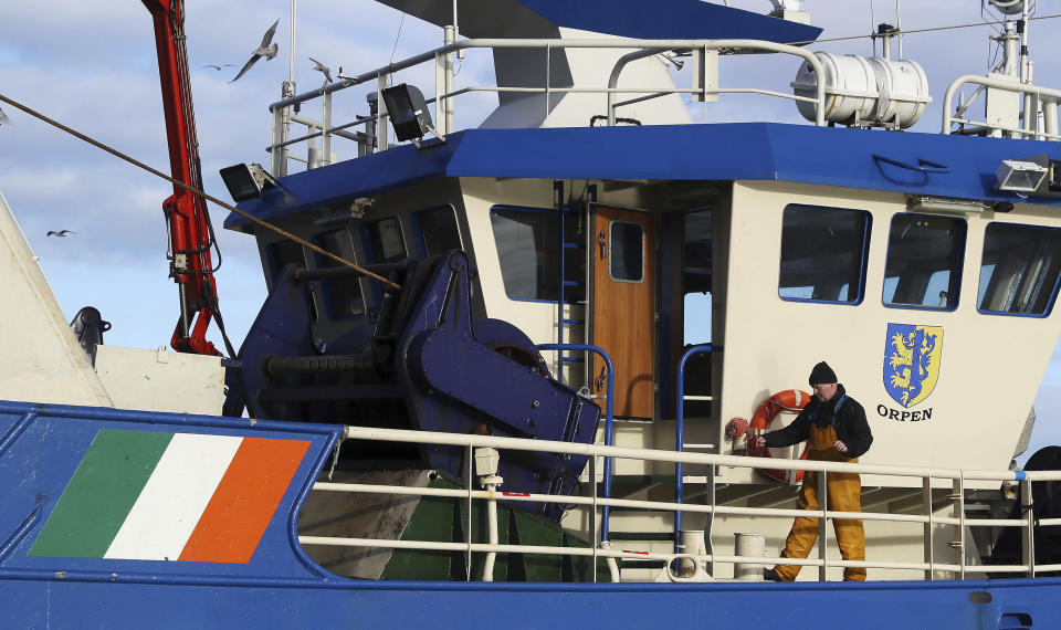 A fisherman aboard a vessel after docking in the fishing village of Howth, Dublin, Ireland, Thursday, Dec. 17, 2020. Irish coastal communities will be "annihilated" if Britain's post-Brexit fishing demands are granted, an Oireachtas committee has been told. (Brian Lawless/PA via AP)