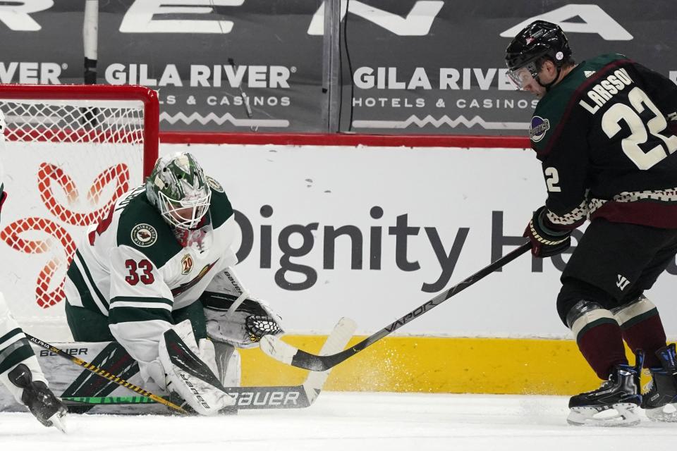 Minnesota Wild goaltender Cam Talbot (33) makes a save on a shot from Arizona Coyotes left wing Johan Larsson (22) during the second period of an NHL hockey game Wednesday, April 21, 2021, in Glendale, Ariz. (AP Photo/Ross D. Franklin)