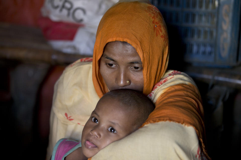 Rohingya refugee woman Jamila Begum holds her daughter Sameera as the family speaks with the Associated Press inside their shelter in Unchiprang refugee camp near Cox's Bazar, in Bangladesh, Friday, Nov. 16, 2018. Normal life returned to a Rohingya Muslim refugee camp in Bangladesh on Friday a day after government officials postponed plans to begin repatriating residents to Myanmar when no one volunteered to go. Begum and her family fled their shanty at the camp on Wednesday fearing they would be repatriated back to Myanmar but returned upon hearing news of protests against the process. (AP Photo/Dar Yasin)