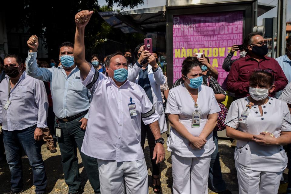 TOPSHOT - Health workers of "20 de Noviembre" hospital farewell his fellow stretcher-bearer Hugo Lopez Camacho, who died of Covid-19, in Mexico City, on May 18, 2020. - The novel coronavirus has killed more than 30,000 people in Latin America and the Caribbean since the outbreak first emerged in China last December, according to the latest tally from official sources compiled by AFP on Monday. (Photo by PEDRO PARDO / AFP) (Photo by PEDRO PARDO/AFP via Getty Images)