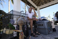 David Muench sits with his birds after being rescued from Sanibel Island in the wake of Hurricane Ian, Friday, Sept. 30, 2022, in Fort Myers, Fla. (AP Photo/Steve Helber)