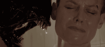 From "Alien": an alien opens its horrible dripping mouth right next to a terrified Sigourney Weaver