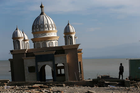 A police officer stands next to the remains of a mosque destroyed by the earthquake and tsunami in Palu, Central Sulawesi, Indonesia, October 5, 2018. REUTERS/Athit Perawongmetha