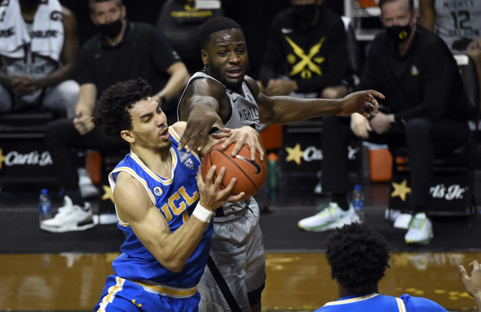 UCLA guard Jules Bernard (1)] and Oregon forward Eugene Omoruyi (2) battle for a rebound during the first half of an NCAA college basketball game Wednesday, March 3, 2021, in Eugene, Ore. (AP Photo/Andy Nelson)