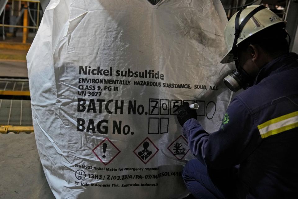 A worker writes batch numbers on a bag of nickel matte at PT Vale Indonesia's processing plant in Sorowako, South Sulawesi, Indonesia, Tuesday, Sept. 12, 2023. Demand for critical minerals like nickel and cobalt is surging as climate change hastens a transition to renewable energy, boosting carbon emissions by miners and processors of such materials. (AP Photo/Dita Alangkara)