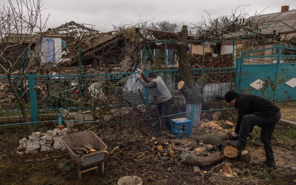 Victor Tsap prepares wood for the winter season next to his destroyed house in the village of Pravdyne, outside Kherson - ROMAN PILIPEY/EPA-EFE/Shutterstock