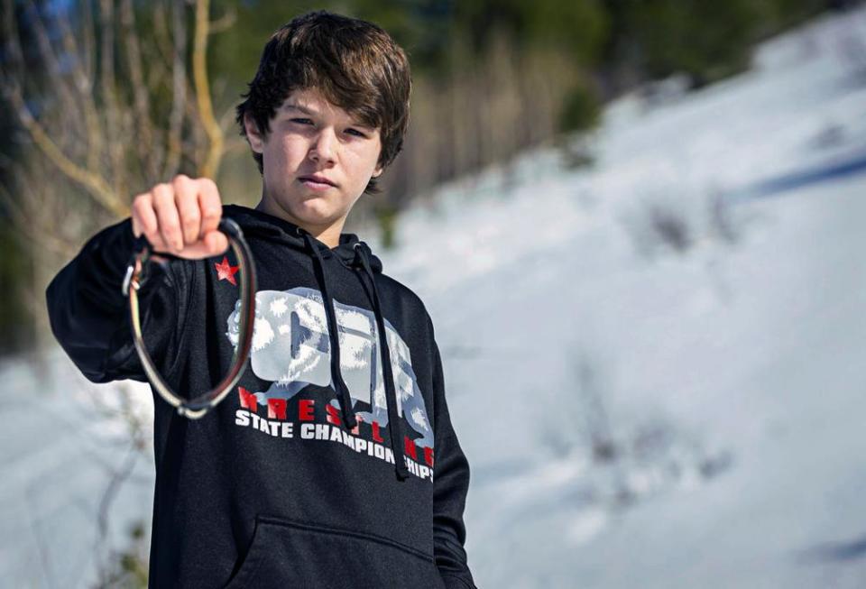 Canyon Mansfield holds the collar of his dog, Casey, who was by a cyanide-ejecting device placed on public land near his home in Pocatello, Idaho.