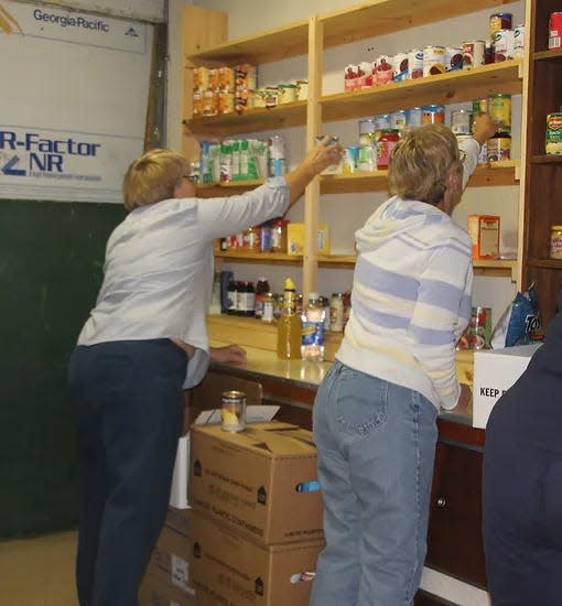Workers stock the food pantry at St. Stephen's Lutheran Church in Feasterville. Church leader Pastor Maeve Schurz says she has seen an increase in need due to the end of SNAP Emergency Allotment disbursements.