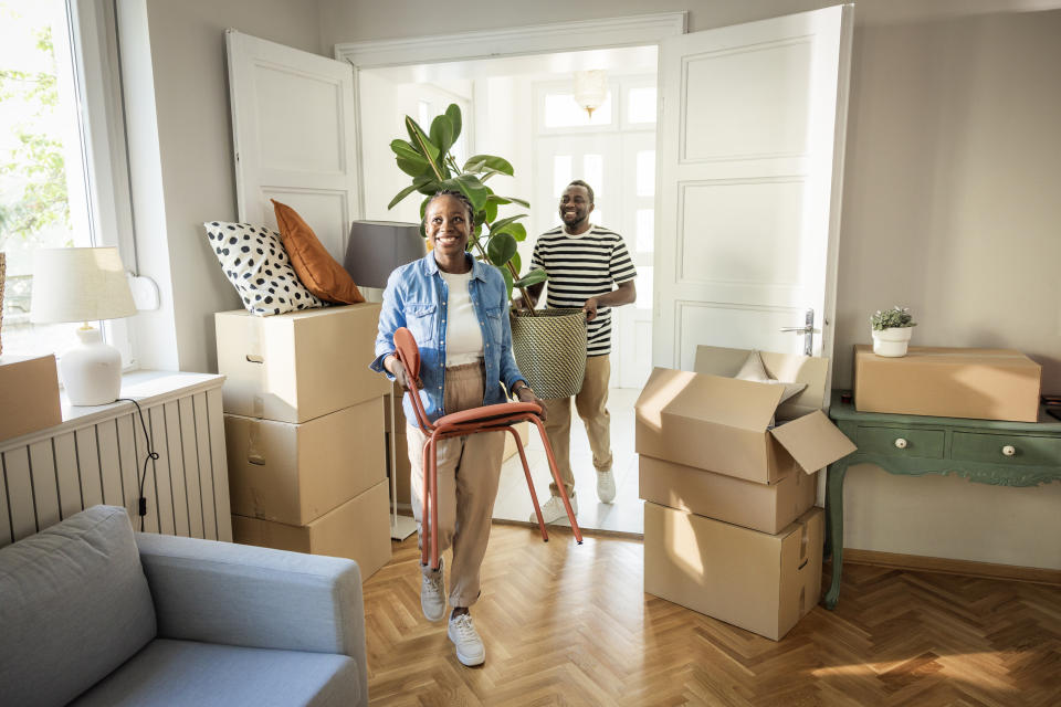 Young couple moving in to their new home, unpacking boxes and enjoying the time together.