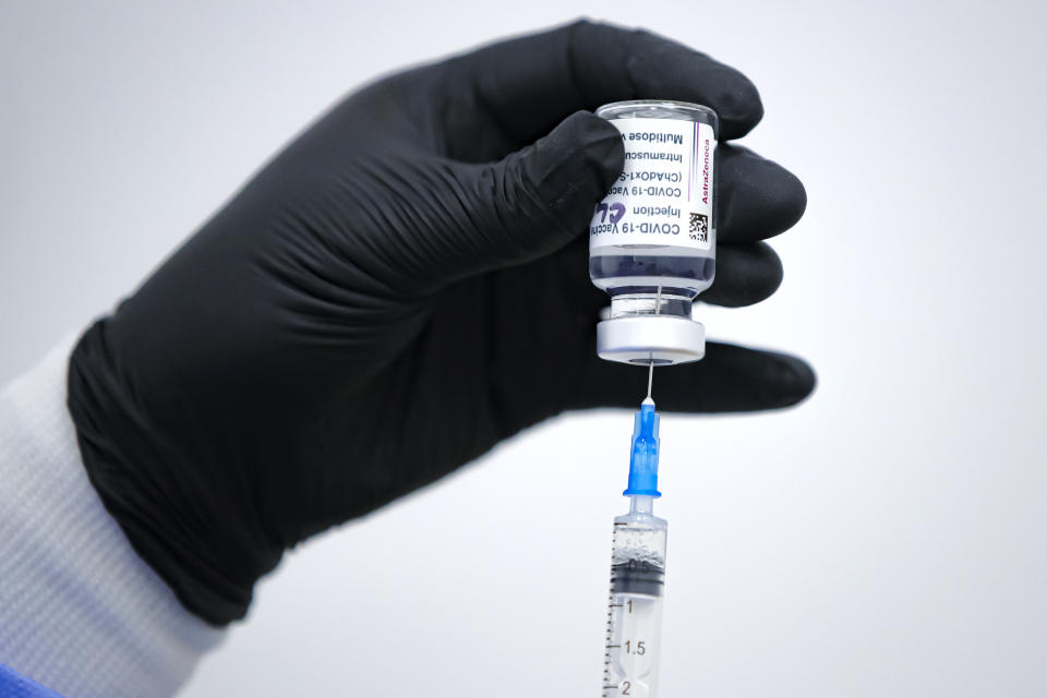 A member of the medical staff draws serum from an AstraZeneca vaccine container at a vaccination center in Bucharest, Romania, Wednesday, April 7, 2021. British authorities recommended Wednesday that the AstraZeneca COVID-19 vaccine not be given to adults under 30 where possible because of strengthening evidence that the shot may be linked to rare blood clots, a recommendation that came as regulators both in the United Kingdom and the European Union emphasized that the benefits of receiving the vaccine continue to outweigh the risks for most people — even though the European Medicines Agency said it had found a "possible link" between the shot and the rare clots.(AP Photo/Vadim Ghirda)