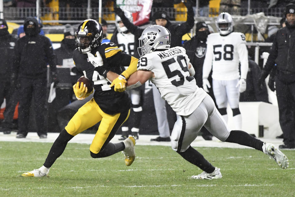 Pittsburgh Steelers wide receiver George Pickens (14) runs after a catch with Las Vegas Raiders linebacker Luke Masterson (59) defending during the second half of an NFL football game in Pittsburgh, Saturday, Dec. 24, 2022. (AP Photo/Fred Vuich)
