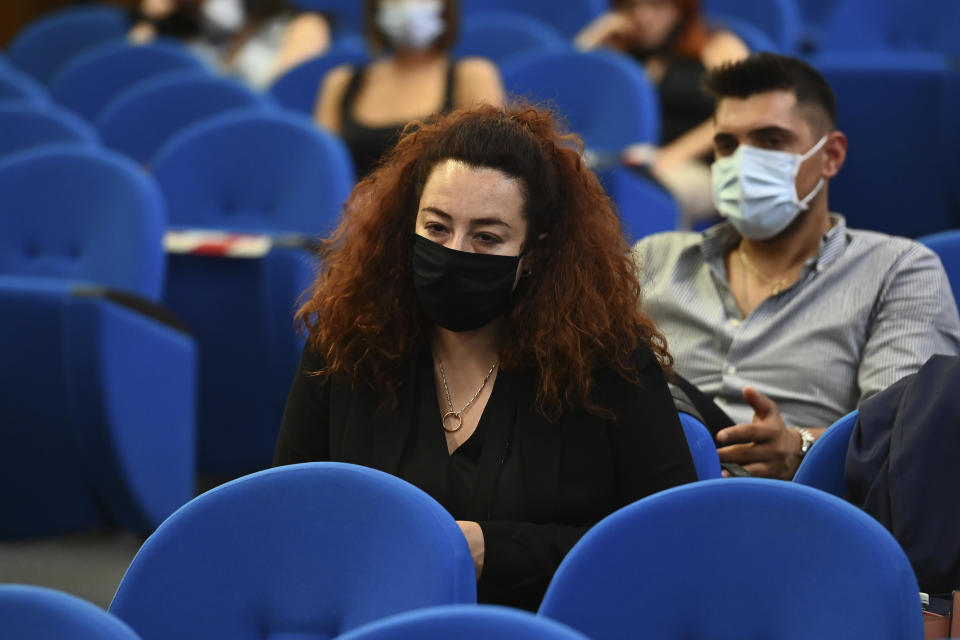 Rosa Maria Esilio and Paolo Cerciello Rega, both wearing face masks, respectively widow and brother of Italian Carabinieri paramilitary police officer Mario Cerciello Rega attend the trial for the killing of Italian Carabinieri police officer Mario Cerciello Rega, in Rome, Wednesday, July 22, 2020. Two tourists from California are accused of murdering Cerciello during their summer vacation in Italy in July 2019. (Andreas Solaro/Pool via AP)