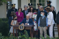 President Joe Biden signs a bill that awards Congressional gold medals to law enforcement officers that protected members on Congress at the Capitol during the Jan. 6 riots, in the Rose Garden of the White House, Thursday, Aug. 5, 2021, in Washington. (AP Photo/Evan Vucci)