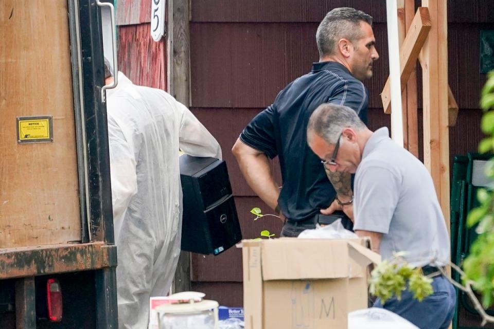 Authorities remove a computer tower as they search the home of suspect Rex Heuermann (Copyright 2023 The Associated Press. All rights reserved.)