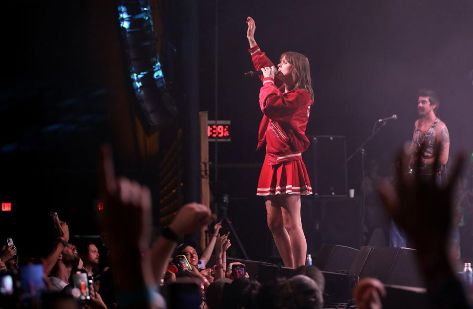 A woman in a cheerleader's outfit performs onstage.